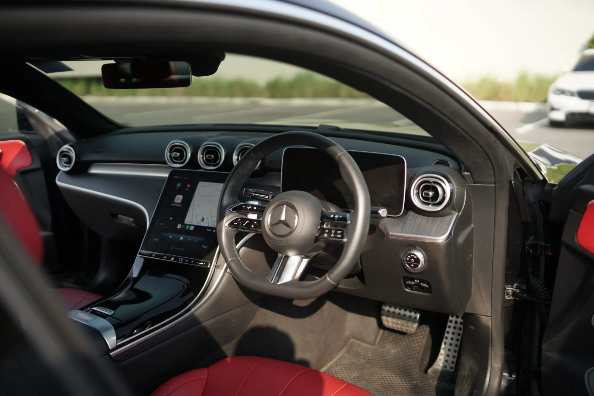 Black and white shot of a luxury Mercedes supercar interior showing steering wheel and rear seating